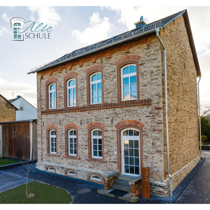 Ein historisches, herrschaftliches Gebäude mit roten Ziegeln und großen Fenstern. Die Fassade zeigt einen charmanten, alten Stil in einer ruhigen Umgebung.