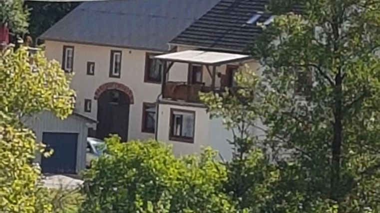 Een charmant huis omringd door bomen en groen. Het heeft een balkon en een vriendelijke, uitnodigende sfeer.