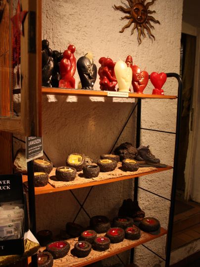 Ein Regal mit bunten Figurinen und Keramiken. Oben sind rote Herzen und Tiere, darunter Töpfe und Schalen.