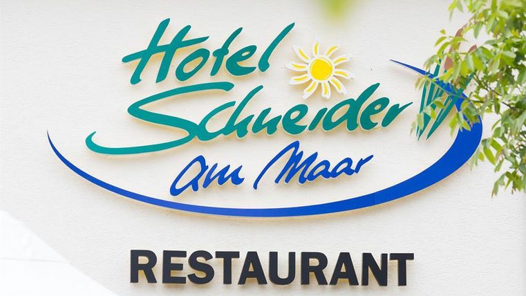 Ein Schild mit dem Namen "Hotel Schneider am Maar" und dem Wort "RESTAURANT" darunter. Die Farben sind hell und einladend, um eine freundliche Atmosphäre zu vermitteln.