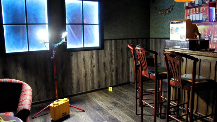 Kamer met houten vloer, bar met barkrukken, twee ramen