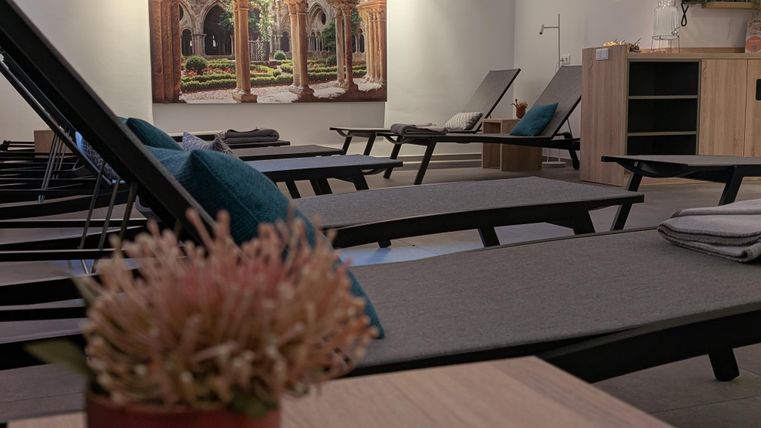 Several loungers are lined up next to each other in a wellness room.