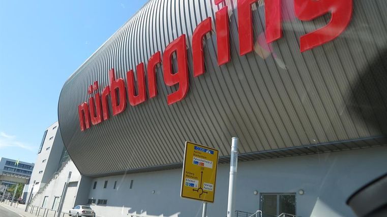 Een modern gebouw met de opvallende tekst "Nürburgring". Het staat in een stedelijke omgeving en maakt deel uit van een racecircuit.