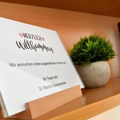 A welcome sign on a side table. Below it are friendly greetings from the team of St. Martin Gastronomy.
