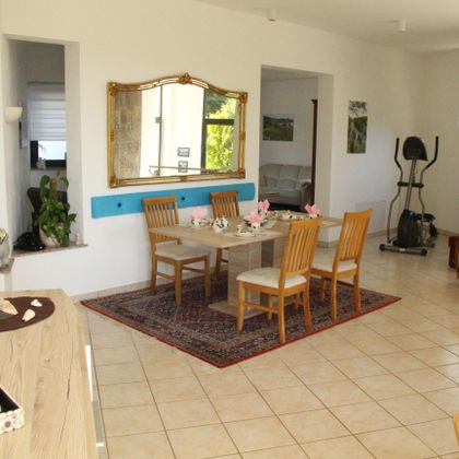 An inviting dining area with a table and chairs. The walls are painted in light colors, and there are decorative elements as well as plants.