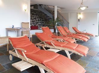 A relaxing wellness area with orange loungers. The room is bright and friendly designed.