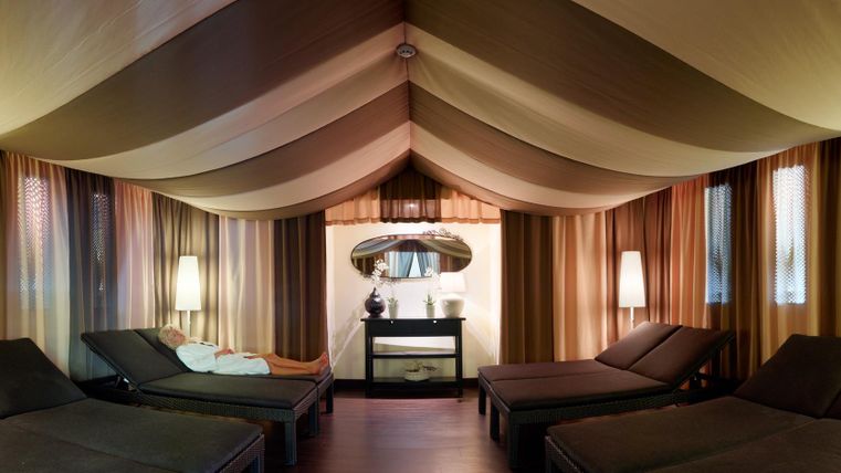 Een ontspannende wellnessruimte met comfortabele ligstoelen en zacht licht. De zachte kleuren en texturen creëren een rustgevende sfeer.