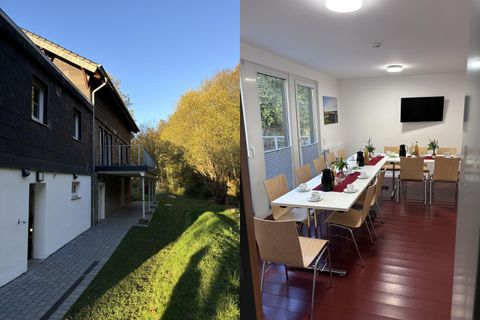 Eine moderne Unterkunft mit einem schönen Außenbereich und klar blauem Himmel. Drinnen befindet sich ein einladender Besprechungsraum mit Tischen und Stühlen.