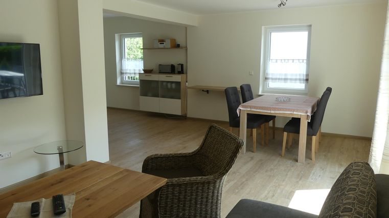 Ein heller und moderner Wohnraum mit einem gemütlichen Sitzbereich und einem Essbereich. Die Küche ist gut ausgestattet und ermöglicht eine angenehme Atmosphäre.