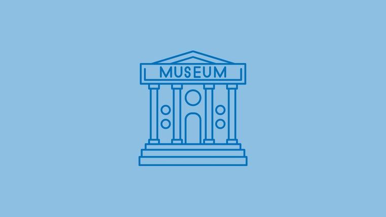 Een eenvoudig blauw gebouw met het woord "MUSEUM" op het dak. Het heeft pilaren en een centrale ingang.