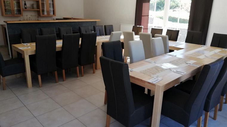 A modern restaurant with several tables and stylish chairs. The large front windows ensure plenty of natural light.