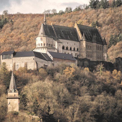 Das Schloss Vianden thront majest&auml;tisch auf einem H&uuml;gel, umgeben von herbstlich gef&auml;rbten B&auml;umen und einem bew&ouml;lkten Himmel., &copy; Jengel