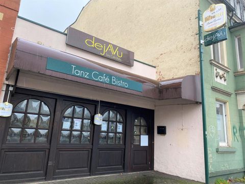 Ein bistro mit dem Namen "dejaVu" steht im Vordergrund. Es handelt sich um ein Tanzcafé mit einem einladenden Eingangsbereich.