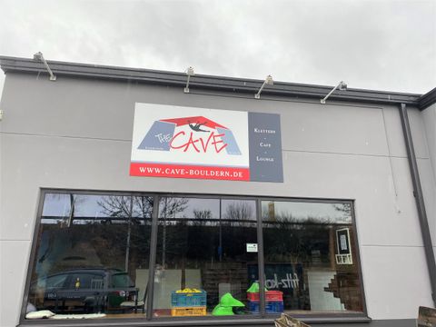 A modern store with a colorful sign. Various toys and items are visible in the shop window.
