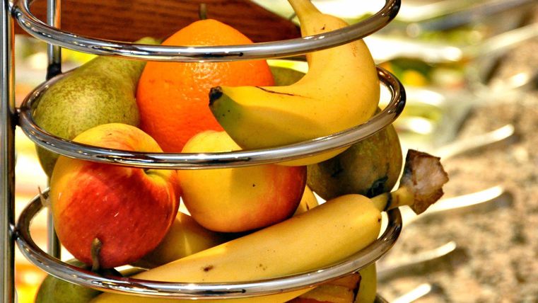 Ein Obstkorb mit verschiedenen Früchten wie Äpfeln, Bananen, Birnen und Orangen. Die Farben sind frisch und einladend.