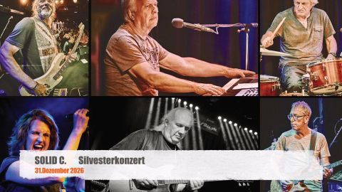 Ein Konzert mit mehreren Musikern, die auf der Bühne spielen. Verschiedene Instrumente und leidenschaftliche Darbietungen sind zu sehen.