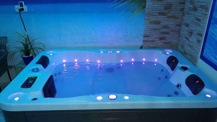 Ein moderner Whirlpool mit bunten Lichtern und klarem Wasser. Die Umgebung wirkt entspannend und einladend.