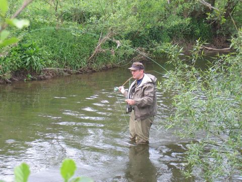 Man staat in de Kyll met een hengel in de hand