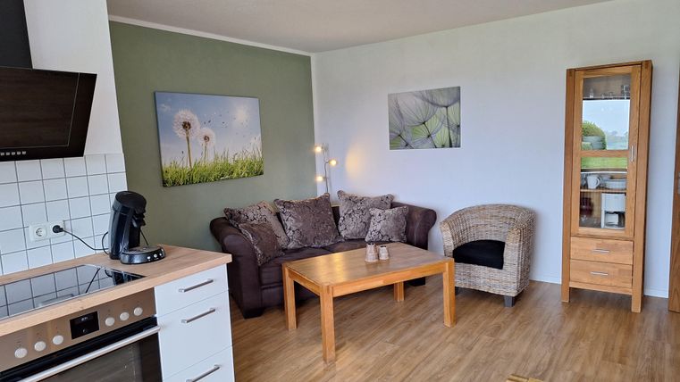 Een gezellige woning met een moderne keuken en een woonkamer. De ruimte is helder en vriendelijk ingericht, met een ruime woonkamerinrichting.