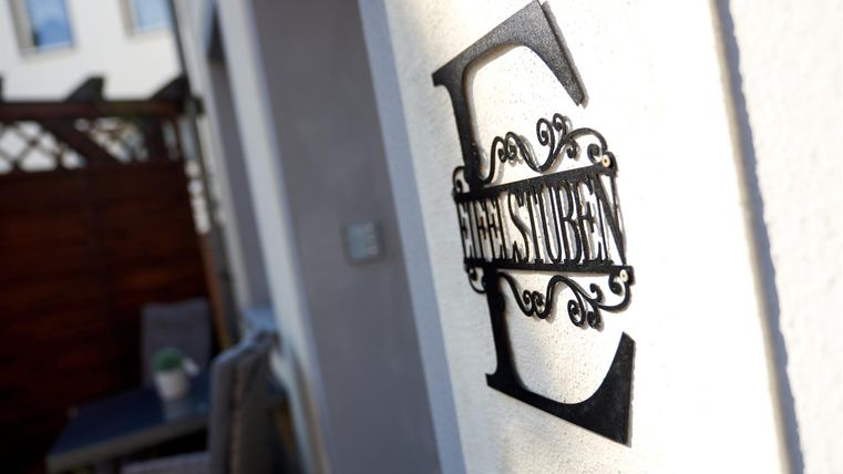 A black sign with the word "Food" is attached to a wall. In the background, chairs and a terrace are visible.