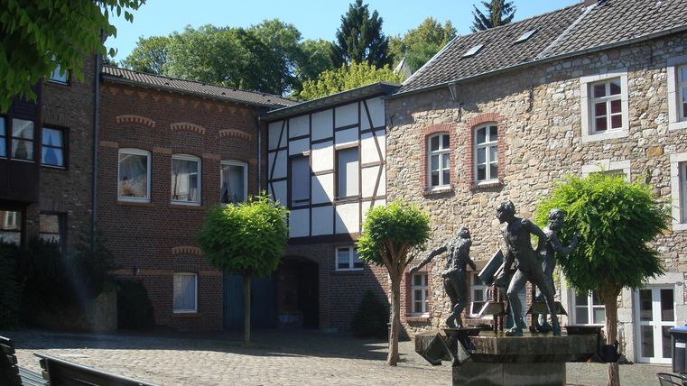 Alter Markt in Stolberg mit Fachwerkhäusern und Brunnen.