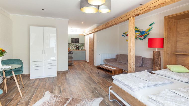 Ein modernes und helles Apartment mit Holzfußböden und gemütlicher Einrichtung. Die Wohnung verfügt über ein Doppelbett, eine Sitzecke und eine Küche.