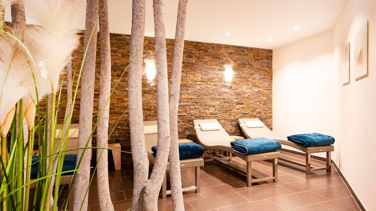 A tranquil wellness area with loungers and modern wooden elements. Soft lighting and a pleasant atmosphere invite relaxation.