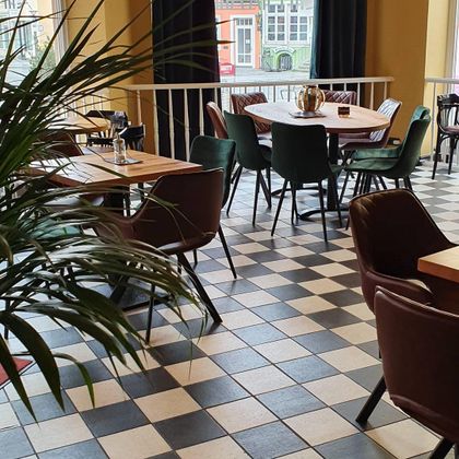 Ein modernes Restaurant mit einem stilvollen Checkermusterboden. Die Tische sind gut platziert und bieten Platz für die Gäste.