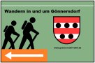 Bord met twee wandelaars, een wapenschild en een pijl die naar links wijst. Tekst: "Wandelen in en rond G&ouml;nnersdorf" en link naar website., &copy; Touristik GmbH Gerolsteiner Land