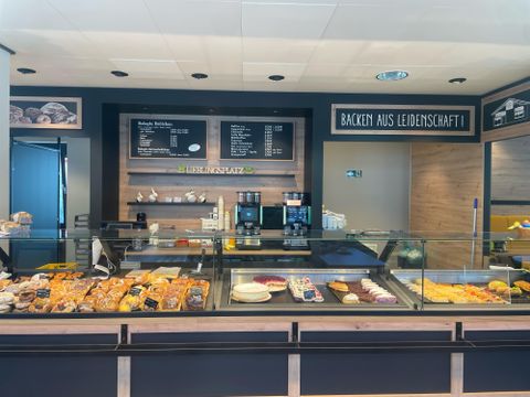 Een moderne bakkerij met een assortiment van verse bakproducten. De toonbank is netjes en uitnodigend ingericht.