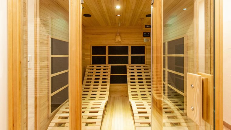 A bright sauna with wood paneling and wooden loungers. The pleasant atmosphere invites relaxation.