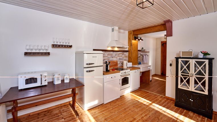 A bright kitchen with modern appliances and wooden flooring. The room is tastefully furnished and offers plenty of space.