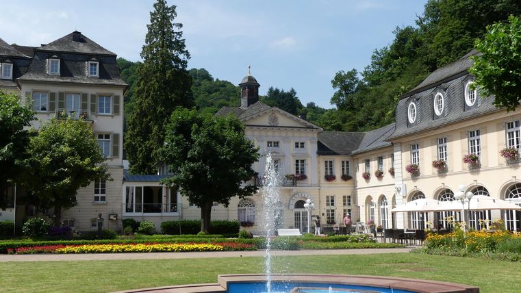 Een mooie binnenplaats met een fontein en verzorgde tuinen. De omliggende gebouwen zijn in klassieke stijl gebouwd.