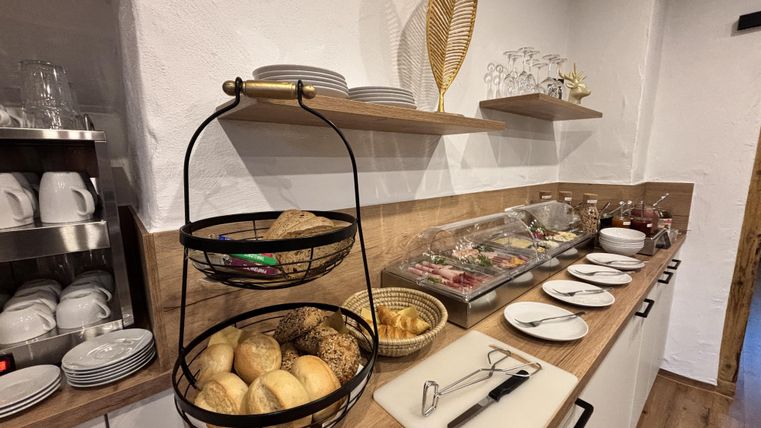 Küchenzeile mit ästhetisch angerichteten Brötchenkörben mit verschiedenen Aufstrichen und Belägen daneben.