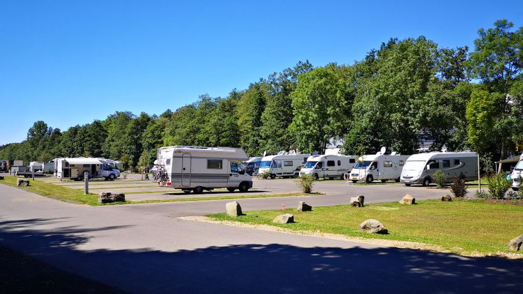 Een rustige camping met verschillende campers en veel groene ruimte. De sfeer is vredig en uitnodigend.