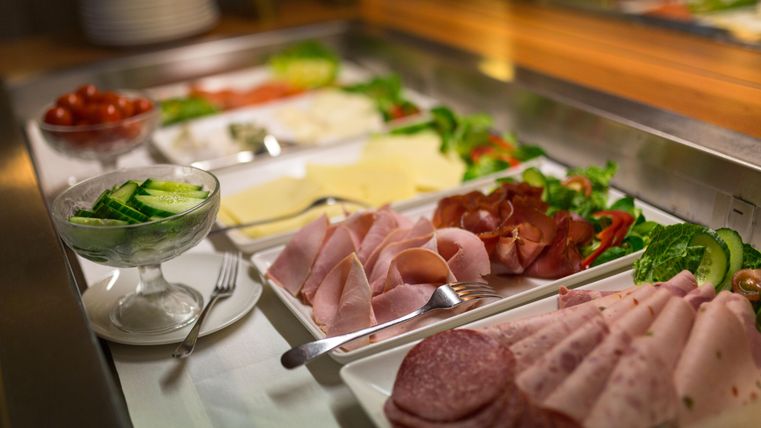 Ein reizvolles Buffet mit verschiedenen Wurst- und Käsesorten, frischem Gemüse und Salat. Die Präsentation ist ansprechend und einladend.