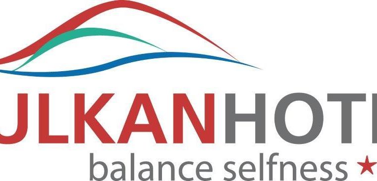 Das Logo des Vulkanhotels mit dem Slogan "Balance Selfness" und drei Sternen. Es zeigt eine stilisierte Berglandschaft in den Farben Rot, Blau und Grün.