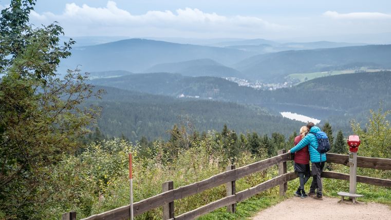 2 Wanderer blicken vom Auersberg über die hügelige Landschaft