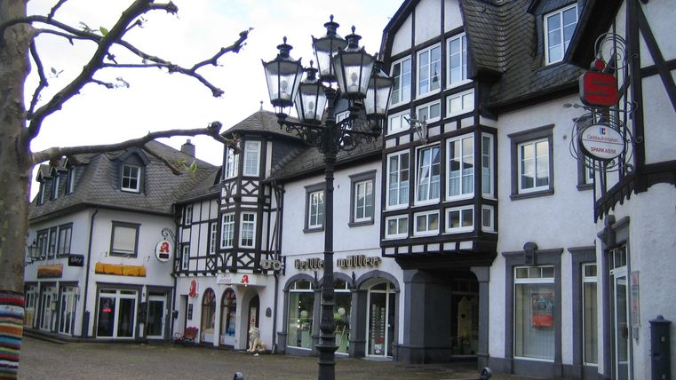 Een pittoreske markt met vakwerkhuizen en een gezellig bankje. De omgeving is rustig en uitnodigend.