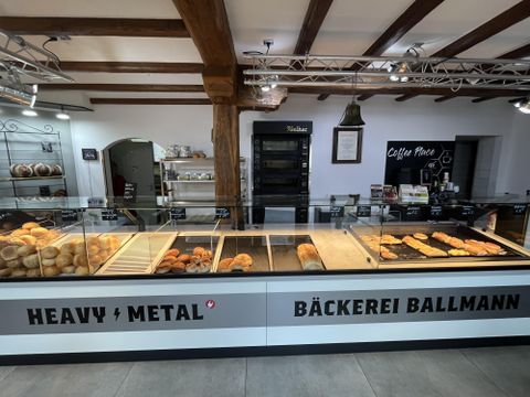 Interior bakery in white with wooden beams, counter with bakery goods