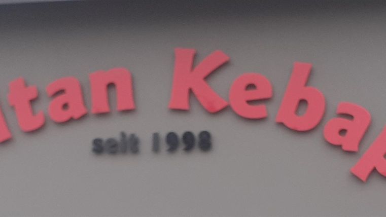 Ein Schild mit der Aufschrift "Sultan Kebap" in roten Buchstaben. Es zeigt an, dass das Restaurant seit 1998 besteht.
