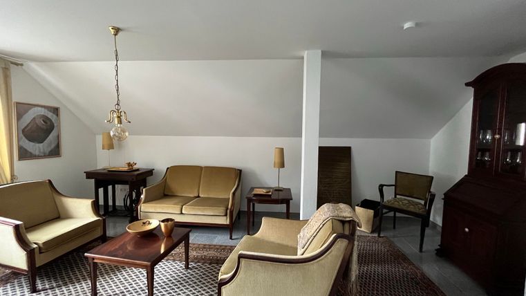 Ein gemütliches Wohnzimmer mit zwei bequemen Sofas, einem Couchtisch und einem Teppich. An der Wand hängt ein Kunstwerk und das Licht ist hell und freundlich.