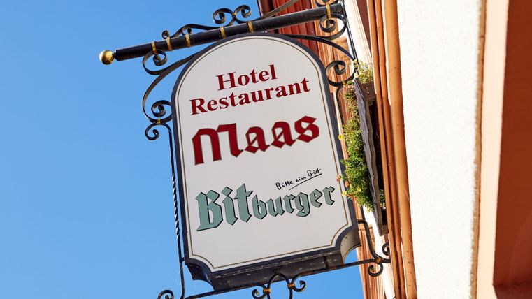 Een bord van Hotel en Restaurant Maas. Het toont de Bitburger-brouwerij als partner.