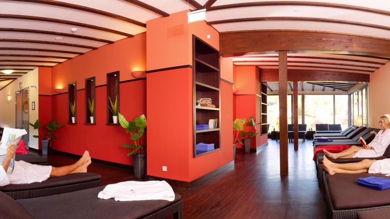 Ein moderner Entspannungsbereich mit komfortablen Liegen und warmen Farben. Die Atmosphäre ist ruhig und einladend.