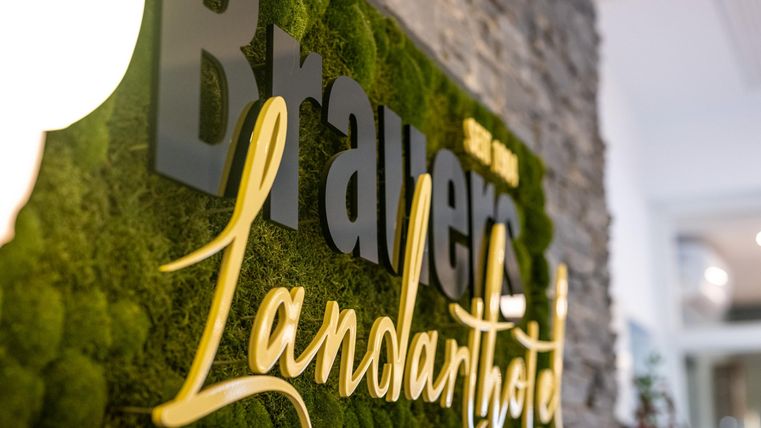 An attractive sign with the name "Landarthotel" in a green moss design. The combination of stone and green elements creates an inviting atmosphere.