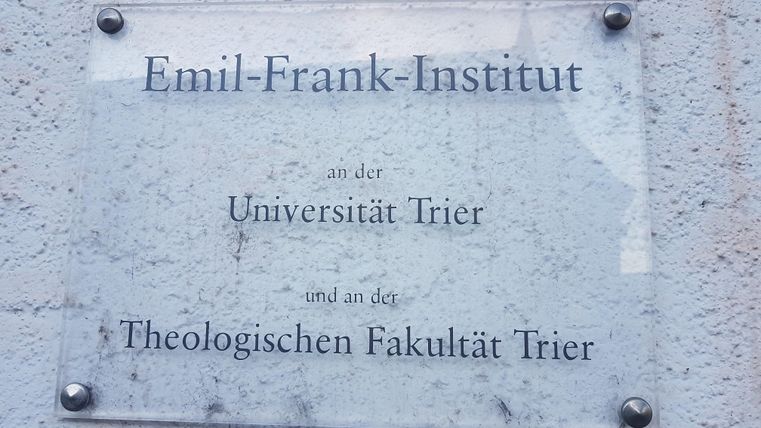 Ein Schild des Emil-Frank-Instituts an der Universität Trier. Es zeigt die Zugehörigkeit zur Theologischen Fakultät Trier.