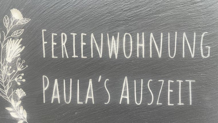 Een bord met de tekst "Vakantiewoning Paula's Uitwijk". Het toont een uitnodigende sfeer voor vakantie gasten.