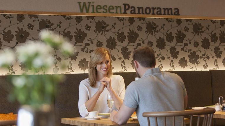 Ein stilvolles Restaurant mit einer schönen Einrichtung. Zwei Personen genießen ein Gespräch bei Kaffee.