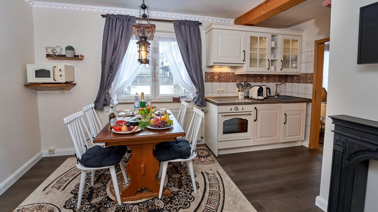 A cozy kitchen with a dining table and chairs. Fresh fruit and an inviting atmosphere make the room welcoming.
