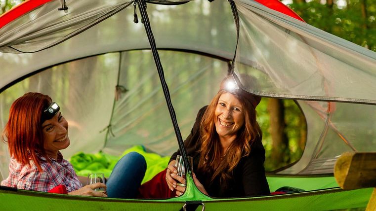 Twee vrouwen in de boomhut met hoofdlamp